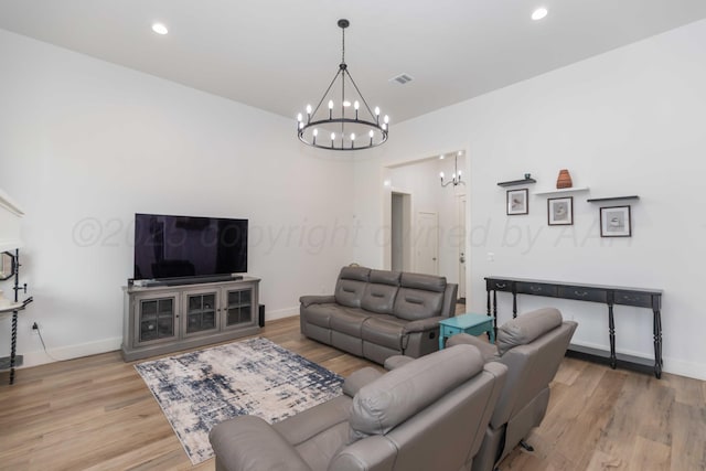 living room featuring light wood-style flooring, a chandelier, visible vents, baseboards, and recessed lighting