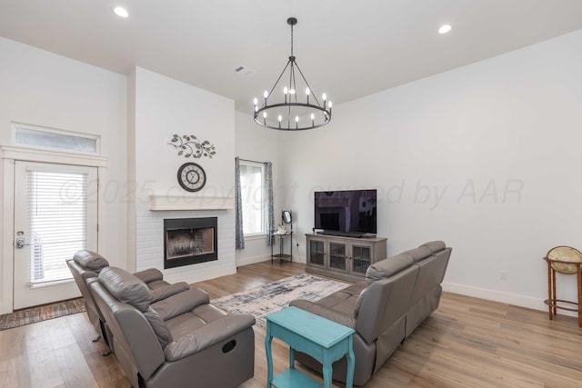 living room with a healthy amount of sunlight, recessed lighting, a notable chandelier, and light wood-style floors