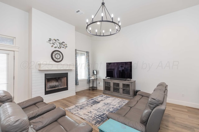 living room with a notable chandelier, a wealth of natural light, wood finished floors, and visible vents