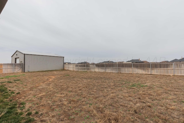 view of yard featuring a pole building, an outbuilding, and a fenced backyard