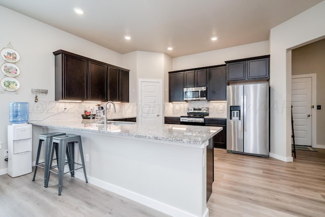 1800 Morningside Ave, Amarillo, TX 79118 - kitchen with appliances with stainless steel finishes, a peninsula, light stone countertops, light wood-style floors, and recessed lighting