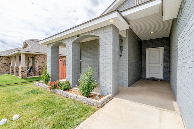 1800 Morningside Ave, Amarillo, TX 79118 - property entrance with brick siding, a yard, a porch, and a carport