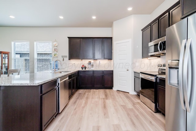 1800 Morningside Ave, Amarillo, TX 79118 - kitchen featuring appliances with stainless steel finishes, light stone countertops, backsplash, dark brown cabinetry, and light wood-style floors
