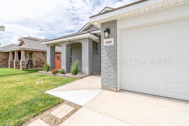1800 Morningside Ave, Amarillo, TX 79118 - view of exterior entry featuring a porch, a yard, brick siding, and a garage