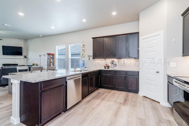 1800 Morningside Ave, Amarillo, TX 79118 - kitchen with stainless steel appliances, a peninsula, light wood-style flooring, open floor plan, and tasteful backsplash