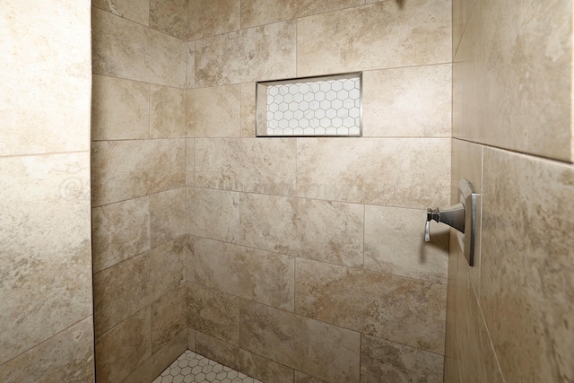 interior details with a tile shower