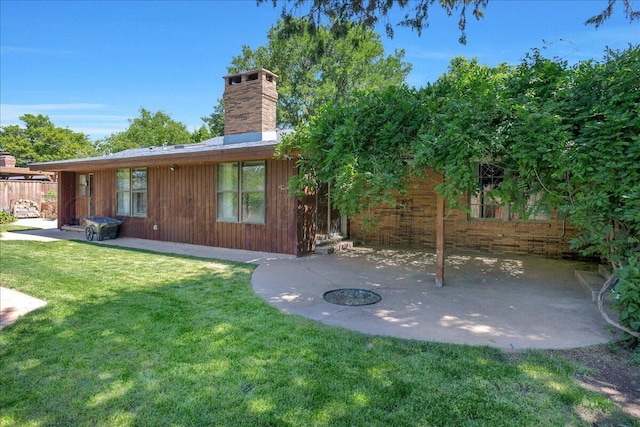 1805 S Julian Blvd, Amarillo, TX 79102 - rear view of house with a patio, a chimney, and a lawn