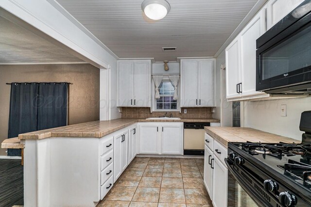 3704 Fountain Ter, Amarillo, TX 79106 - kitchen with black appliances, decorative backsplash, a peninsula, and white cabinets