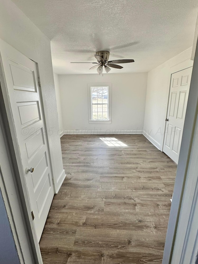 1106 Coke St, Vega, TX 79092 - unfurnished room with baseboards, wood finished floors, ceiling fan, and a textured ceiling