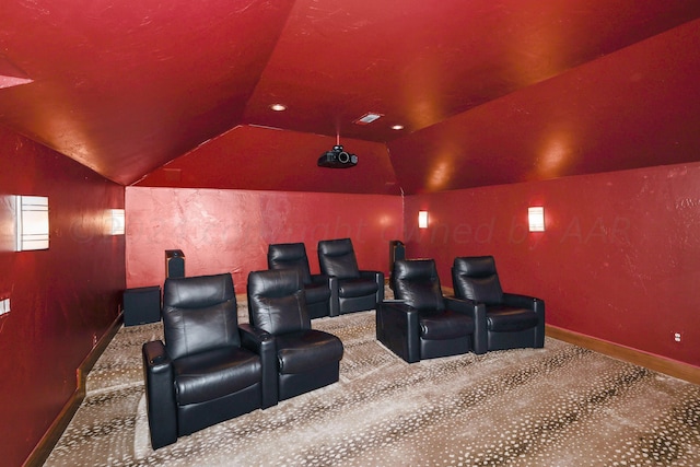 carpeted home theater with vaulted ceiling