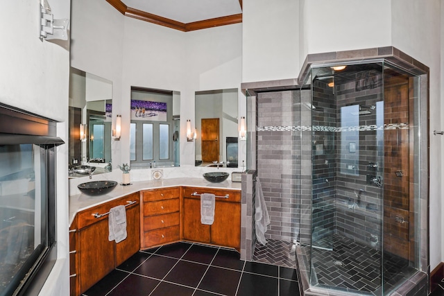 bathroom featuring tile patterned floors, vanity, a shower with shower door, and ornamental molding