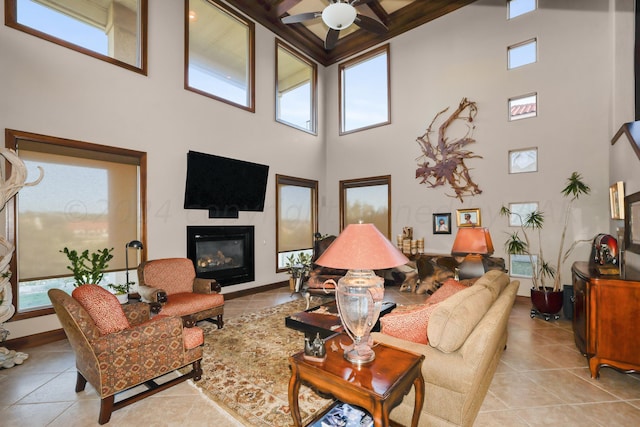 living room featuring a high ceiling, ceiling fan, and light tile patterned flooring