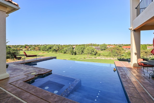 view of swimming pool with an in ground hot tub