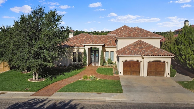 mediterranean / spanish-style home with a front yard and a garage