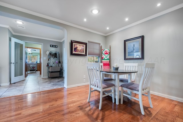 dining room with ornamental molding and light wood-type flooring