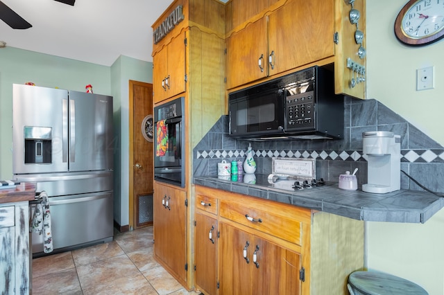 kitchen with light tile patterned floors, decorative backsplash, ceiling fan, and black appliances