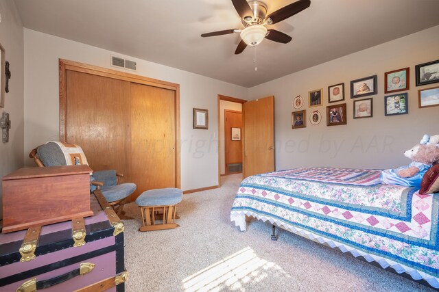 carpeted bedroom with ceiling fan and a closet