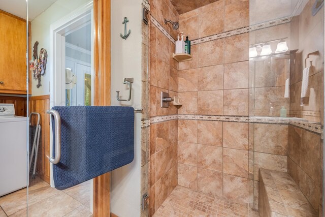 bathroom with sink, a shower with door, tile patterned flooring, ornamental molding, and washer / clothes dryer