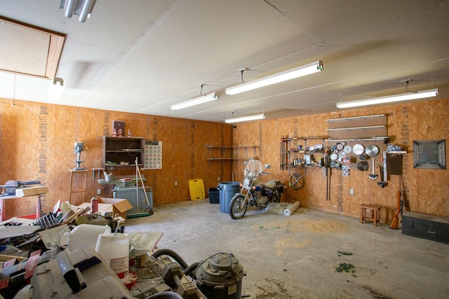 garage featuring wooden walls and a workshop area