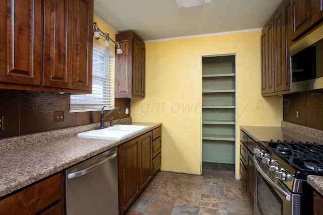 kitchen featuring crown molding, stainless steel appliances, sink, and decorative backsplash