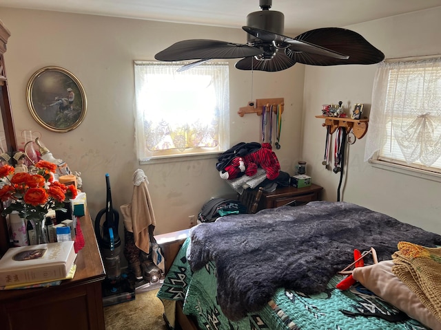 bedroom featuring ceiling fan, multiple windows, and carpet