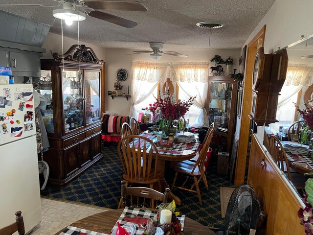 dining space featuring ceiling fan, a textured ceiling, and light carpet