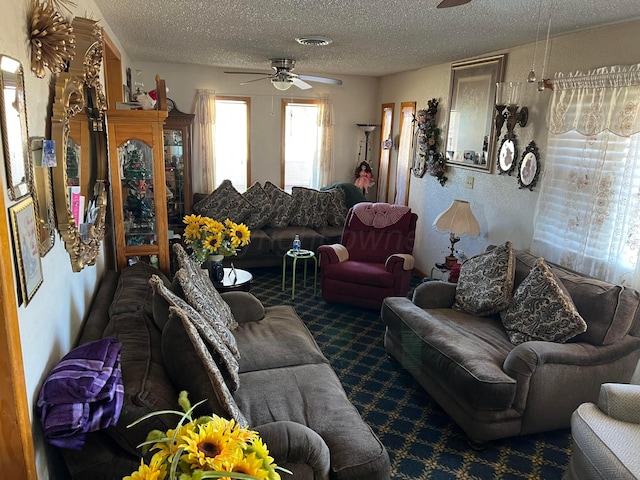 living room featuring ceiling fan and a textured ceiling