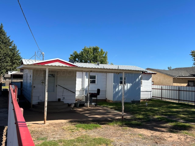 rear view of house featuring a yard and a patio