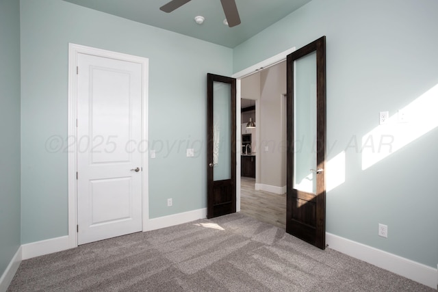 unfurnished bedroom featuring carpet flooring, baseboards, and ceiling fan