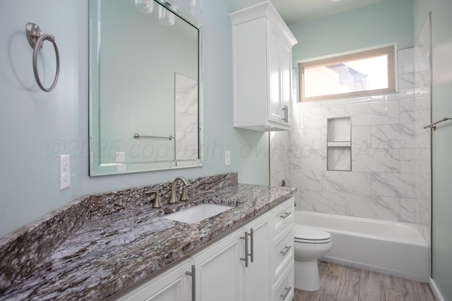 bathroom featuring wood finished floors, vanity, washtub / shower combination, and toilet