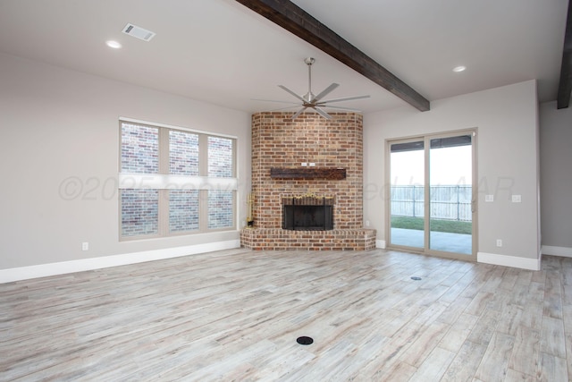 unfurnished living room featuring visible vents, a ceiling fan, light wood-style floors, beam ceiling, and a brick fireplace