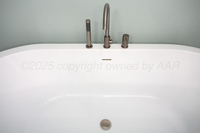 interior details featuring a soaking tub and a sink