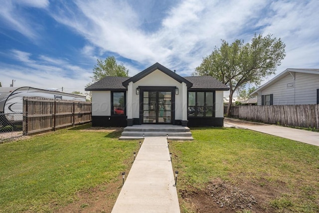 view of front of property with french doors, roof with shingles, fence, a front lawn, and stucco siding