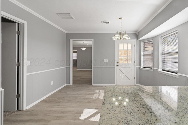 unfurnished dining area with light hardwood / wood-style flooring, crown molding, and plenty of natural light