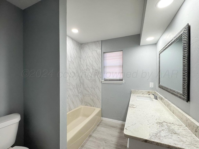 full bathroom with wood-type flooring, vanity, toilet, and tiled shower / bath combo