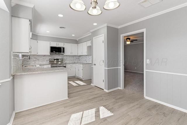 kitchen featuring stainless steel appliances, white cabinetry, decorative backsplash, light hardwood / wood-style floors, and ceiling fan with notable chandelier