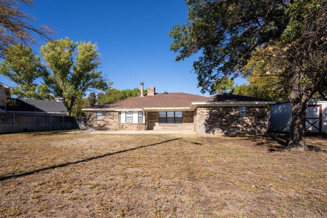 rear view of house featuring a lawn