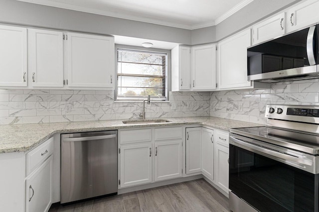 kitchen with white cabinets, stainless steel appliances, ornamental molding, and sink