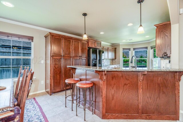 3507 Spokane Ave, Amarillo, TX 79118 - kitchen with freestanding refrigerator, a breakfast bar, light stone countertops, ornamental molding, and a peninsula