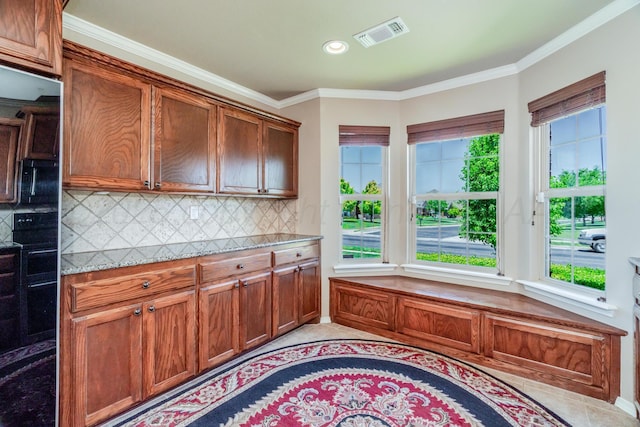 3507 Spokane Ave, Amarillo, TX 79118 - kitchen featuring light tile patterned floors, backsplash, ornamental molding, brown cabinetry, and recessed lighting