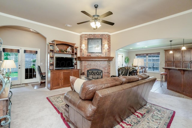 3507 Spokane Ave, Amarillo, TX 79118 - living area with arched walkways, light colored carpet, a fireplace, ceiling fan, and crown molding