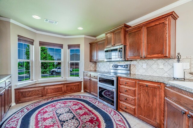 3507 Spokane Ave, Amarillo, TX 79118 - kitchen featuring stainless steel appliances, healthy amount of natural light, backsplash, light tile patterned flooring, and ornamental molding