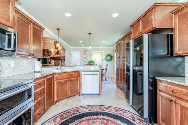 3507 Spokane Ave, Amarillo, TX 79118 - kitchen with stainless steel appliances, brown cabinets, light tile patterned floors, a peninsula, and ornamental molding