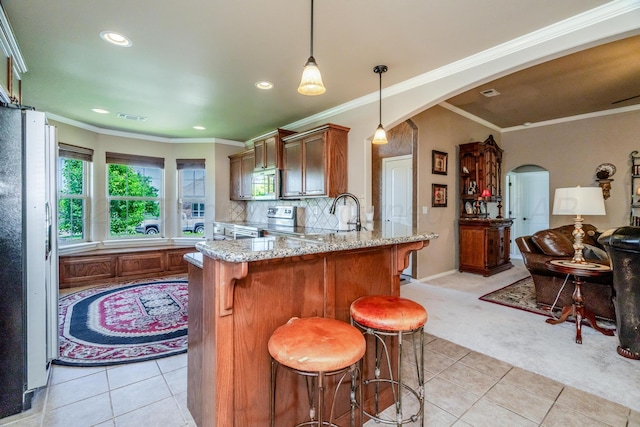 3507 Spokane Ave, Amarillo, TX 79118 - kitchen featuring arched walkways, stainless steel appliances, light colored carpet, light tile patterned floors, and a peninsula