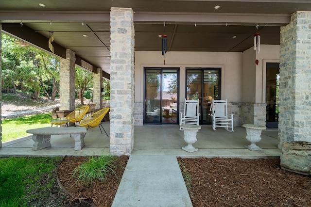 view of exterior entry featuring stucco siding and stone siding