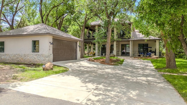 view of front of house with a porch, stucco siding, a balcony, and stone siding