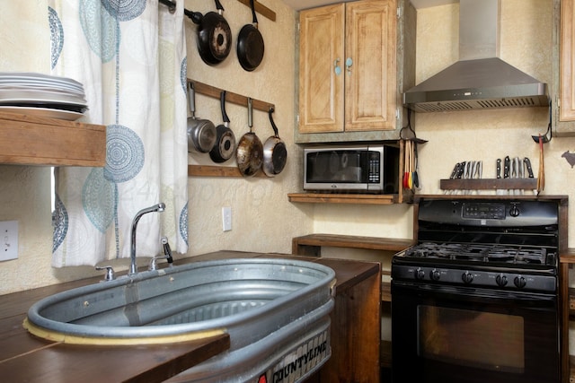 kitchen with stainless steel microwave, dark countertops, gas stove, wall chimney range hood, and a textured wall