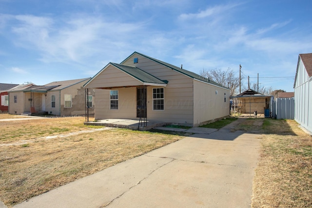 view of front facade with a patio, fence, and a front lawn