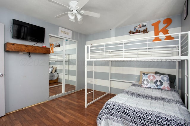 bedroom with a ceiling fan, wood finished floors, and a closet