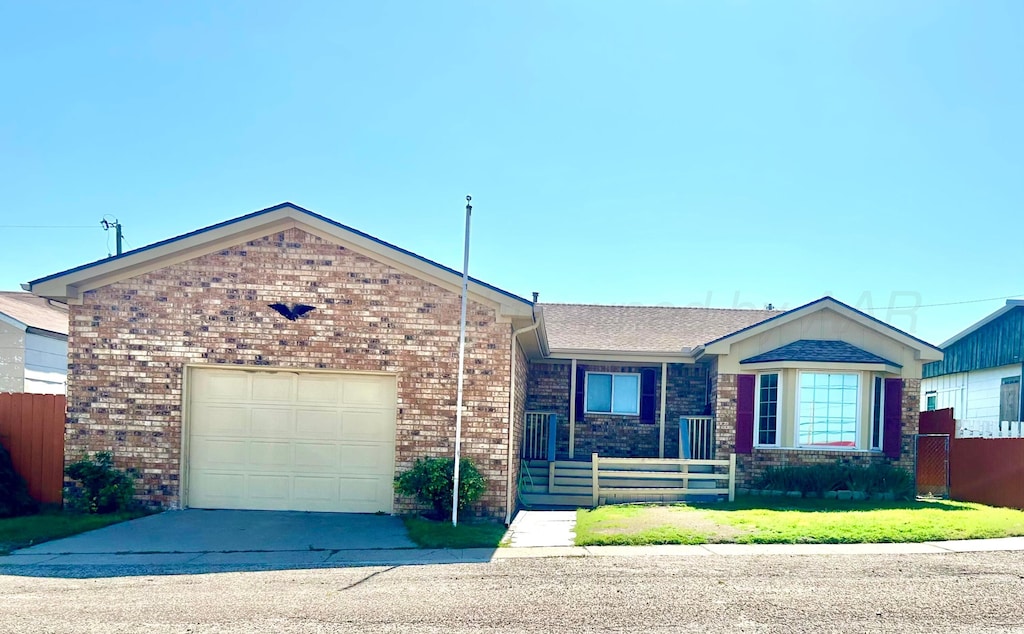 103 Frontera St, Borger, TX 79007 - ranch-style house featuring a fenced front yard, brick siding, a garage, and concrete driveway